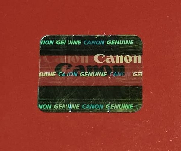 Голограмма Canon при наклоне, тёмно-зелёный цвет с надписями GENUINE